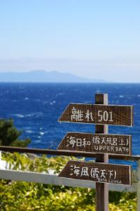 a street sign with signs in english and chinese at Gardenvilla Shirahama in Shimoda
