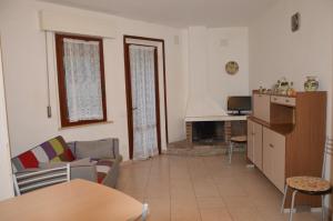 un soggiorno con divano e tavolo di Casa Grazia a soli 100m dal mare Marina di Castagneto a Marina di Castagneto Carducci