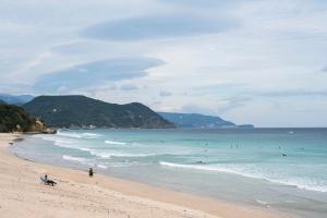 a beach with many people in the water at Gardenvilla Shirahama in Shimoda