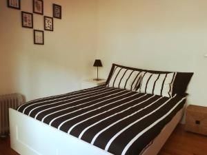 uma cama com almofadas listradas em preto e branco num quarto em Lovely Apartment near Belém em Lisboa