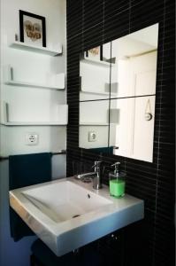 uma casa de banho com um lavatório e um espelho em Lovely Apartment near Belém em Lisboa