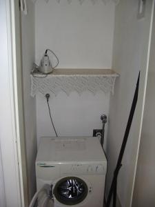 - Lavadora en una habitación pequeña con estantería en Casa Grazia a soli 100m dal mare Marina di Castagneto, en Marina di Castagneto Carducci