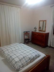 een slaapkamer met een bed, een dressoir en een spiegel bij RIVAROLA in Fanano