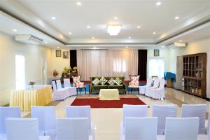 a large room with white chairs and a living room at Amphawaree in Samut Songkhram
