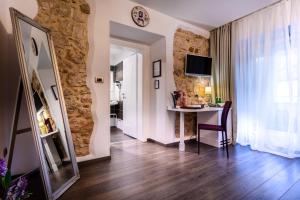a living room with a wooden floor and a clock on the wall at Hotel Heritage Forza in Baška