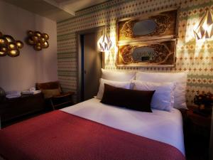 a bedroom with a large white bed and a chair at Casa do Castelo in Sernancelhe