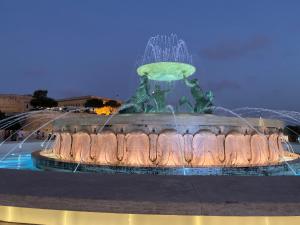 a fountain with a green frog on top of it at Tritoni Valletta Boutique Hotel in Il-Furjana