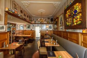 a restaurant with wooden tables and chairs and a bar at BnB prins Hendrik Venlo in Venlo