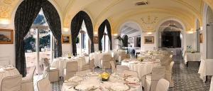 un comedor con mesas blancas y sillas blancas en Hotel Luna Convento, en Amalfi