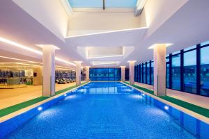 a large swimming pool in a building with windows at Holiday Inn Wuxi Taihu New City by IHG in Wuxi