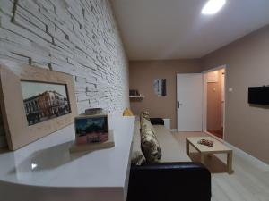 a living room with a couch and a stone wall at Apartman Ana in Šabac