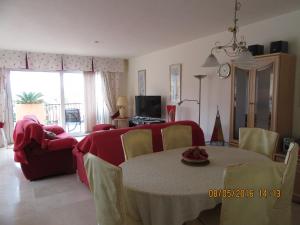 uma sala de estar com uma mesa e um sofá vermelho em Los Granados 431 em Manilva