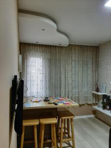 a kitchen with a table and stools in a room at Apartman Ana in Šabac