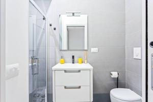 a bathroom with a sink and a toilet and a mirror at Easylife - Milano - D'Annunzio - Navigli in Milan +7 photos