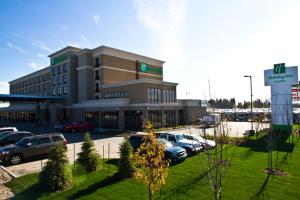 um grande edifício com carros estacionados num parque de estacionamento em Holiday Inn Hotel & Suites Red Deer, an IHG Hotel em Red Deer