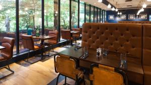 een restaurant met tafels, stoelen en ramen bij Holiday Inn Runcorn M56 Junction 12, an IHG Hotel in Runcorn