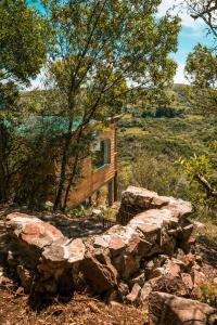 a log cabin in the woods with a stone wall at Camino el Portal del Alma in El Eden