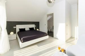 a white bedroom with a bed and a mirror at Casa Rural La Esencia in Araguás