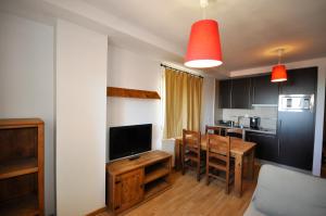 a kitchen and dining room with a table and a television at Apartamentos Sabica in Sierra Nevada