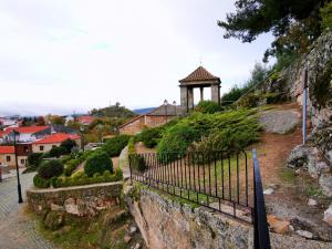 um portão no lado de uma colina com um edifício em Casa do Castelo em Sernancelhe