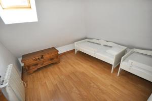 Habitación pequeña con 2 camas y suelo de madera. en Apartamentos Sabica, en Sierra Nevada