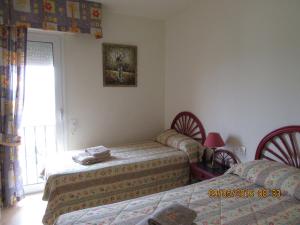 a bedroom with two twin beds and a window at Los Granados 431 in Manilva