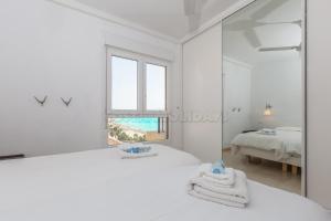 - une chambre blanche avec un miroir et un lit dans l'établissement Los Reales 8C, à Estepona