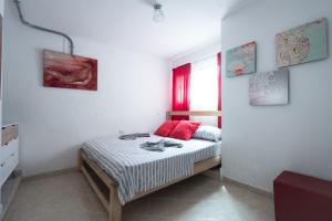 Un dormitorio con una cama con almohadas rojas. en The Sugar Cane Hostel, en Medellín