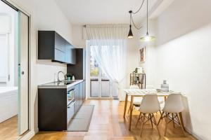 a kitchen with a table and chairs in a room at Easylife - Milano - D'Annunzio - Navigli in Milan