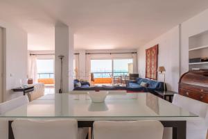 - un salon avec une table en verre et des chaises blanches dans l'établissement Los Reales 8C, à Estepona