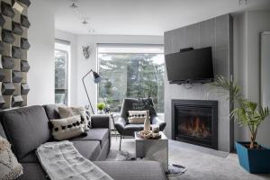 uma sala de estar com um sofá e uma lareira em The Modern Whistler Apartment - Ski-in ski-out em Whistler