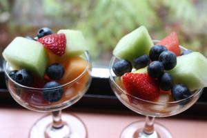 two wine glasses filled with fruit in front of a window at Shawnigan Lake Bed and Breakfast in Shawnigan Lake