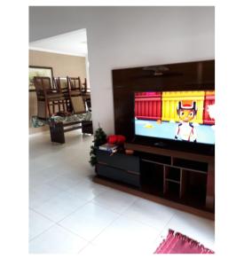 a living room with a tv with a video game on it at Casa Temporada Patricia Lima in Capitólio