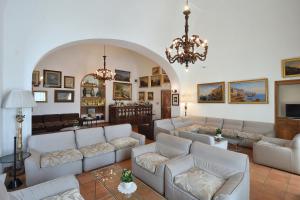 uma sala de estar com sofás brancos e um lustre em Hotel Luna Convento em Amalfi