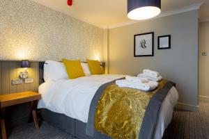 a bedroom with a large bed with towels on it at The Eaton Oak in Saint Neots