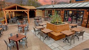 eine Terrasse mit Tischen und Stühlen vor einem Restaurant in der Unterkunft The Eaton Oak in Saint Neots