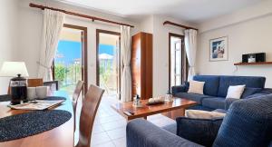 un soggiorno con divano blu e tavolo di 2 bedroom Apartment Helena with private garden, Aphrodite Hills Resort a Kouklia