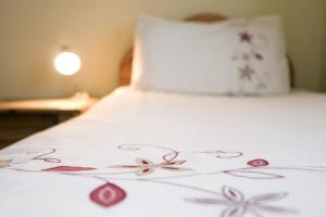 uma cama com um edredão branco com flores em no 3 Leitrim Road em Carrick on Shannon