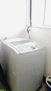 a white refrigerator in a room with a window at Leezahomestay in Bayan Lepas