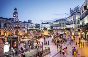 uma multidão de pessoas andando em torno de uma rua movimentada da cidade em Precioso dúplex en la Puerta del Sol. em Madri