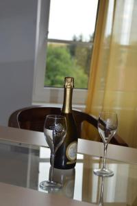 a bottle of champagne and two glasses on a table at Gardenia 2 in Stadtlauringen