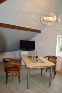 Gardenia 2 في Stadtlauringen: غرفة طعام مع طاولة مع زجاجة نبيذ عليها