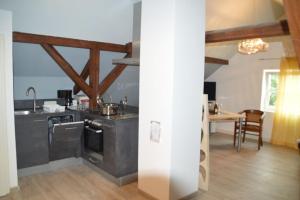 a kitchen with black counters and a dining room at Gardenia 2 in Stadtlauringen