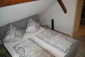 a bed with two pillows on it in a room at Gardenia 2 in Stadtlauringen