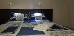 Una cama con almohadas azules y blancas. en Departamento Altos de la Merced en Salta