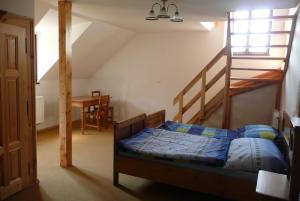a bedroom with a bed and a staircase at Statek Chmelovice in Chmelovice