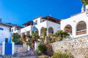 a white house with a stone wall at Villa Ponente in Spetses