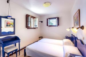 a bedroom with a bed and a blue desk at Villa Ponente in Spetses