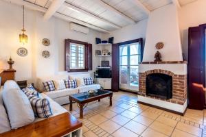a living room with a couch and a fireplace at Villa Ponente in Spetses