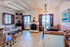 a living room with a couch and a fireplace at Villa Ponente in Spetses